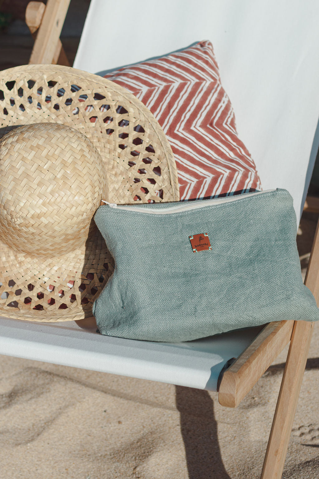 Cosmetic bag pouch in a chair at the beach with summer essentials 