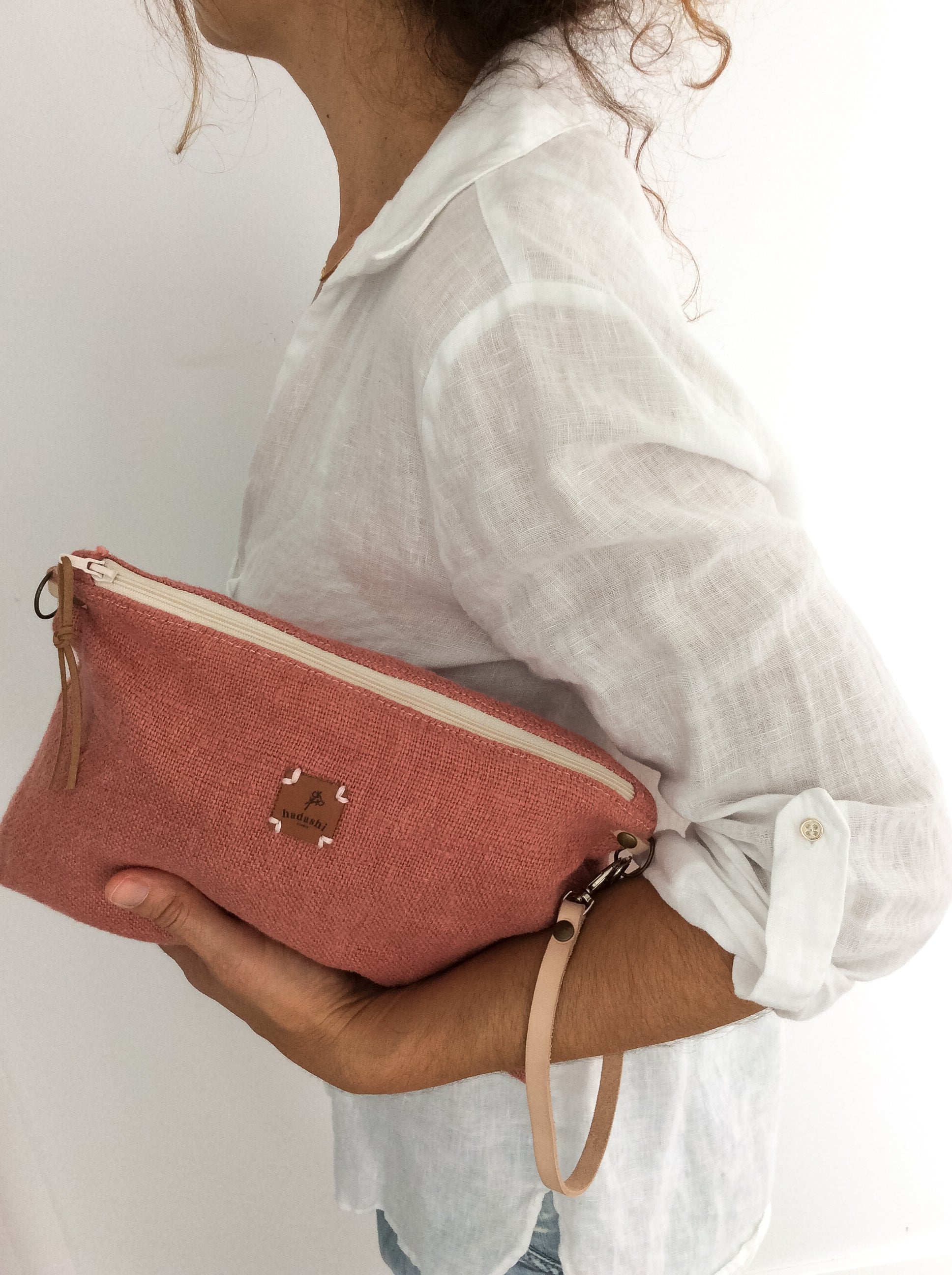 woman wearing white linen shirt and a linen slouchy pouch in rose with a thin leather strap